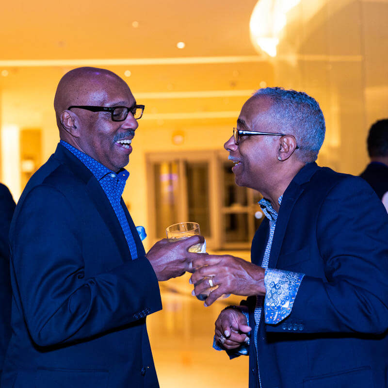 Two men laughing at Howard welcome event