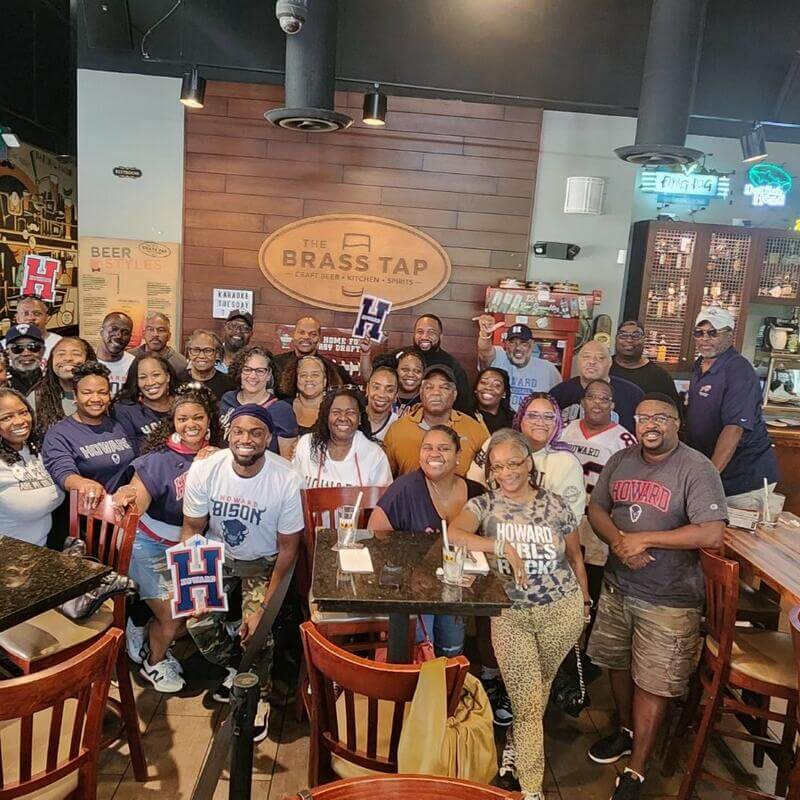 HUAA members posing for large group photo at The Brass Tap
