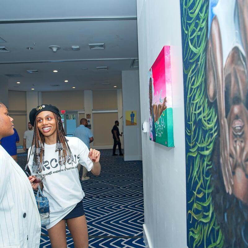 Attendees looking at art on the wall