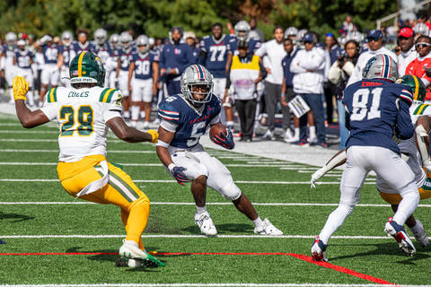 Howard football player about to juke an opposing player