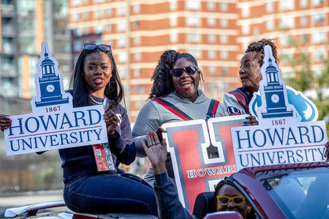 3 Howard women with HU signs in a parade