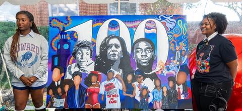 Howard alums standing next to their Howard 100 painting