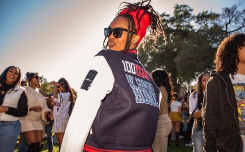 Howard alum wearing Howard 100 varsity jacket at Homecoming