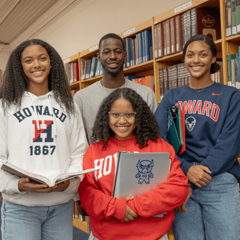 HU students posing for a photo in front of books