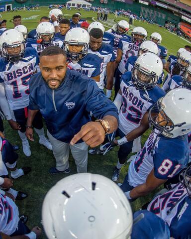 HU Football coach talking to players in huddle