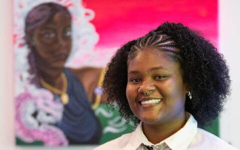 Howard Fine Arts student in front of her art